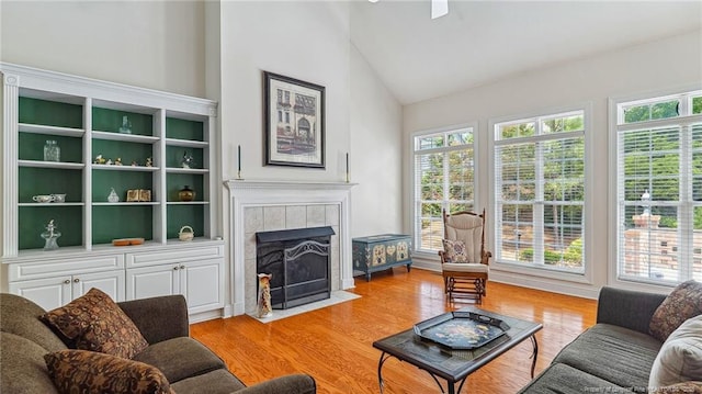202 Juniper Creek Blvd, Pinehurst, NC 28374 - living area with a tiled fireplace, plenty of natural light, light wood-style floors, and high vaulted ceiling