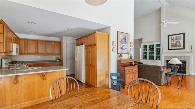 202 Juniper Creek Blvd, Pinehurst, NC 28374 - kitchen featuring white appliances, light wood finished floors, a sink, a peninsula, and ceiling fan
