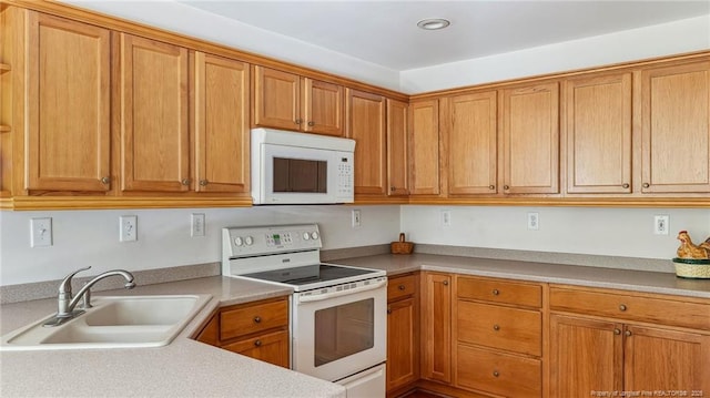 202 Juniper Creek Blvd, Pinehurst, NC 28374 - kitchen featuring white appliances, a sink, light countertops, brown cabinets, and recessed lighting