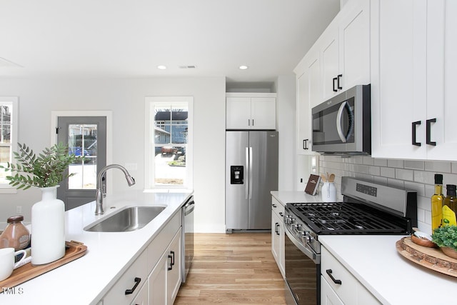 1514 W Knox St, Durham, NC 27705 - kitchen featuring appliances with stainless steel finishes, a sink, recessed lighting, light wood-style flooring, and light countertops