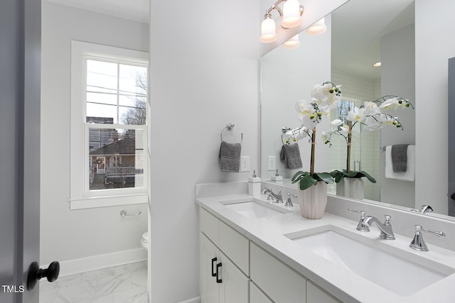 1514 W Knox St, Durham, NC 27705 - full bathroom featuring marble look tiles, double vanity, toilet, and baseboards