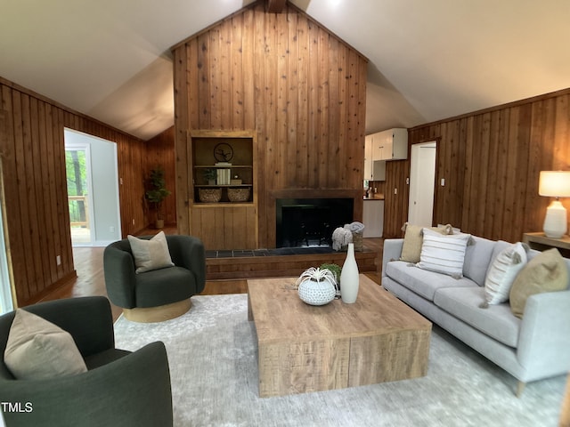 102 Pebble Ct, Chapel Hill, NC 27516 - living room featuring vaulted ceiling, wooden walls, wood finished floors, and a fireplace with raised hearth