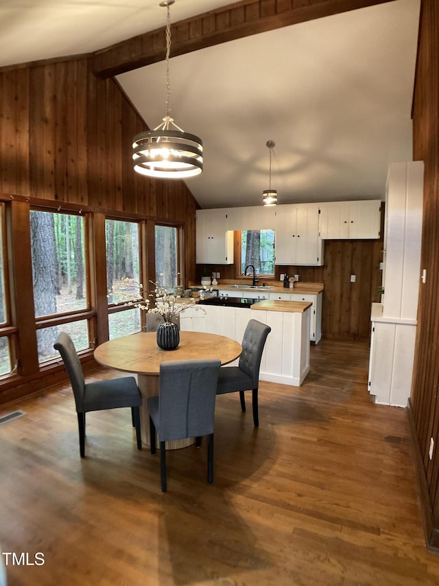 102 Pebble Ct, Chapel Hill, NC 27516 - dining area with wooden walls, a chandelier, beam ceiling, dark wood-style flooring, and high vaulted ceiling