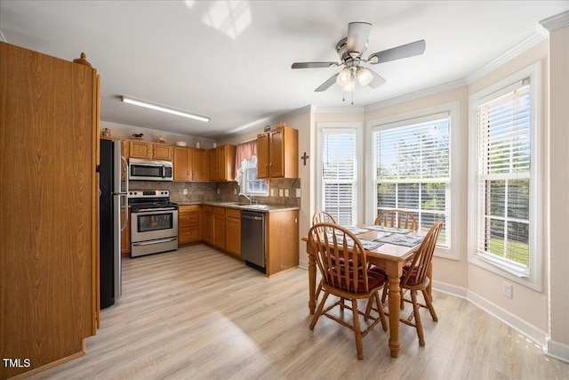 124 Roscommon Ln, Clayton, NC 27520 - kitchen with appliances with stainless steel finishes, light wood-style flooring, crown molding, decorative backsplash, and a sink