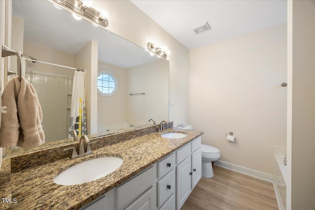 124 Roscommon Ln, Clayton, NC 27520 - bathroom with baseboards, wood finished floors, a bathtub, toilet, and double vanity