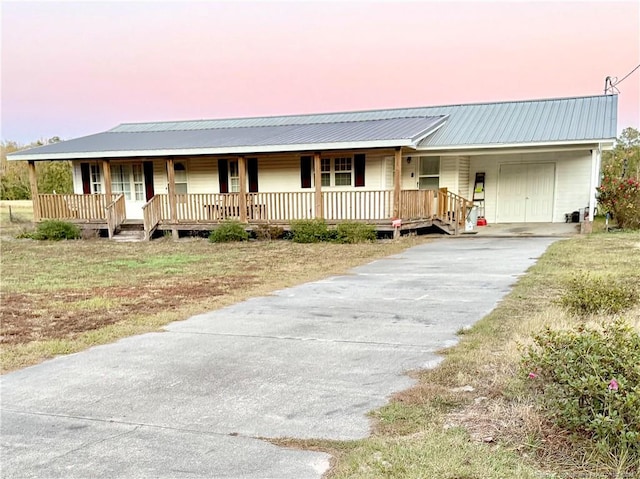 5089 Tobacco Rd, Orrum, NC 28369 - view of front facade featuring a porch, driveway, and metal roof
