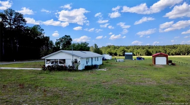 5089 Tobacco Rd, Orrum, NC 28369 - view of home's exterior with a garage, a yard, a forest view, and an outdoor structure