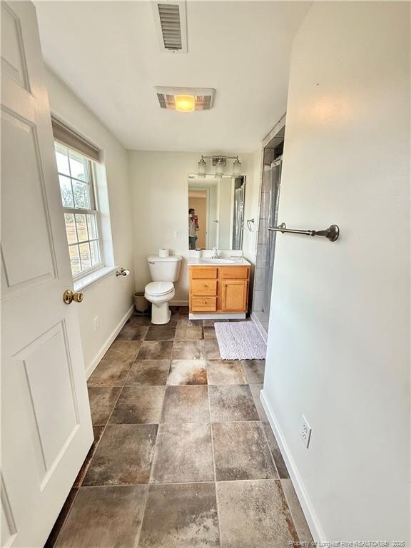 5089 Tobacco Rd, Orrum, NC 28369 - full bathroom with baseboards, vanity, a shower stall, toilet, and stone finish floors