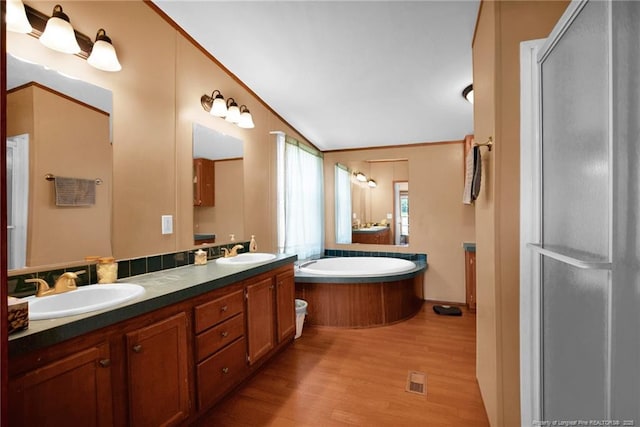 7504 Hidden Ln, Roseboro, NC 28382 - bathroom with vaulted ceiling, wood finished floors, double vanity, and a bath