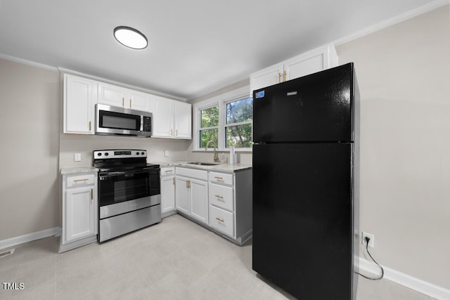 104 Archdale Dr, Durham, NC 27707 - kitchen featuring appliances with stainless steel finishes, a sink, white cabinets, baseboards, and light stone counters