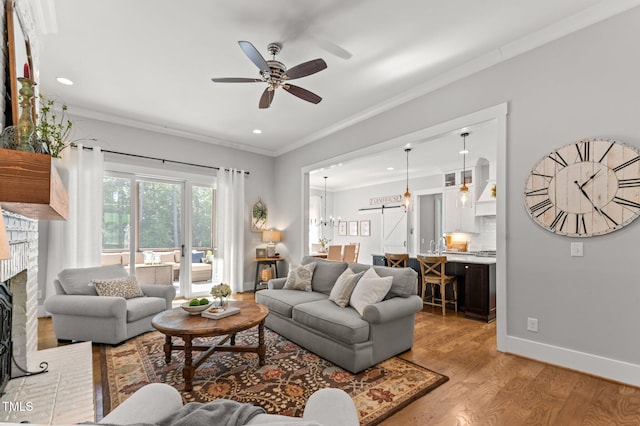 1412 Wakefield Farm Rd, Zebulon, NC 27597 - living area featuring a ceiling fan, light wood-type flooring, recessed lighting, ornamental molding, and a brick fireplace