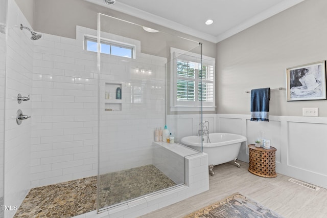 1412 Wakefield Farm Rd, Zebulon, NC 27597 - bathroom featuring a shower stall, a freestanding tub, a wainscoted wall, crown molding, and wood finished floors