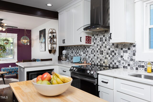 2805 Fayetteville St, Durham, NC 27707 - kitchen featuring wall chimney exhaust hood, electric stove, decorative backsplash, white cabinetry, and recessed lighting