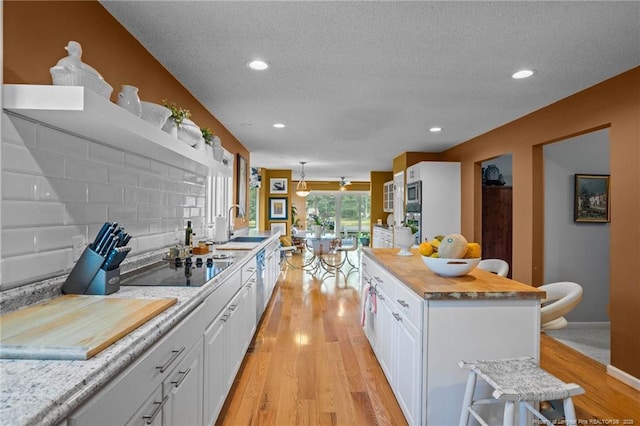 116 Fox Run Ct, West End, NC 27376 - kitchen featuring a textured ceiling, white cabinets, stainless steel appliances, light wood finished floors, and recessed lighting