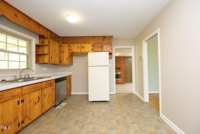 1209 Landon St, Durham, NC 27703 - kitchen with freestanding refrigerator, dishwasher, a sink, tile countertops, and baseboards