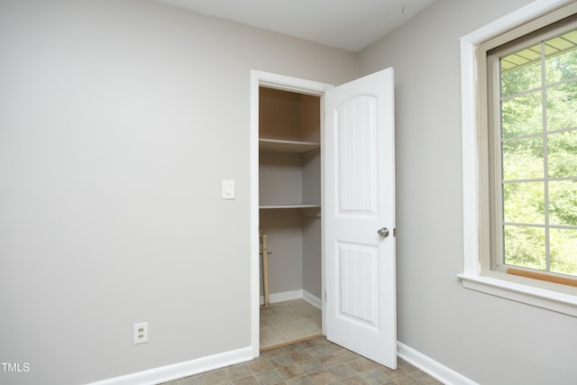 1209 Landon St, Durham, NC 27703 - unfurnished bedroom featuring a walk in closet, baseboards, and a closet