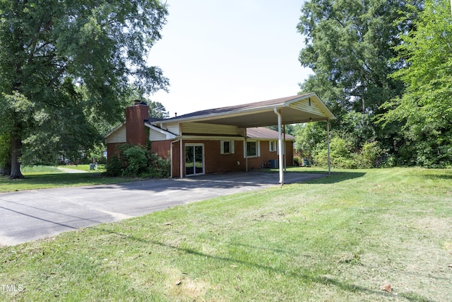 1209 Landon St, Durham, NC 27703 - back of house with asphalt driveway, a chimney, a yard, and brick siding