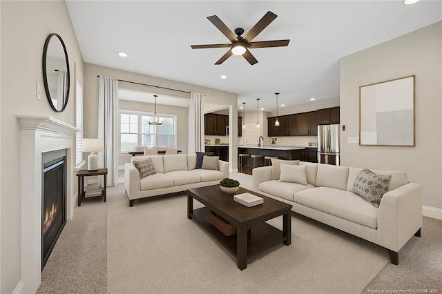 405 Gilpin Way, Cary, NC 27519 - living room with light carpet, a ceiling fan, recessed lighting, a glass covered fireplace, and a chandelier