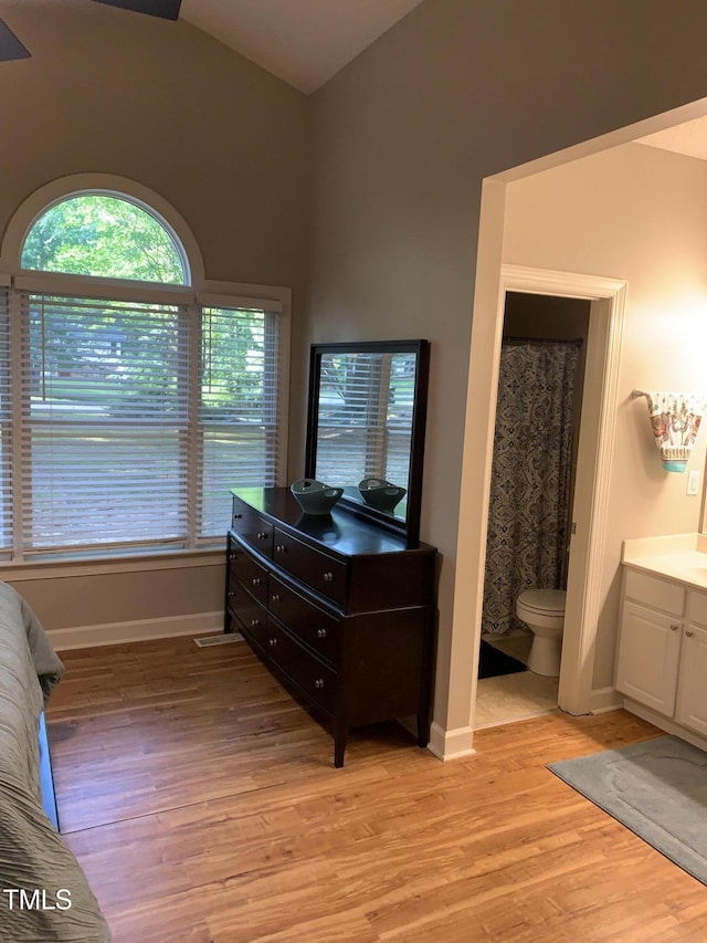 352 Riverstone Dr, Clayton, NC 27527 - full bath featuring wood finished floors, vanity, lofted ceiling, toilet, and baseboards
