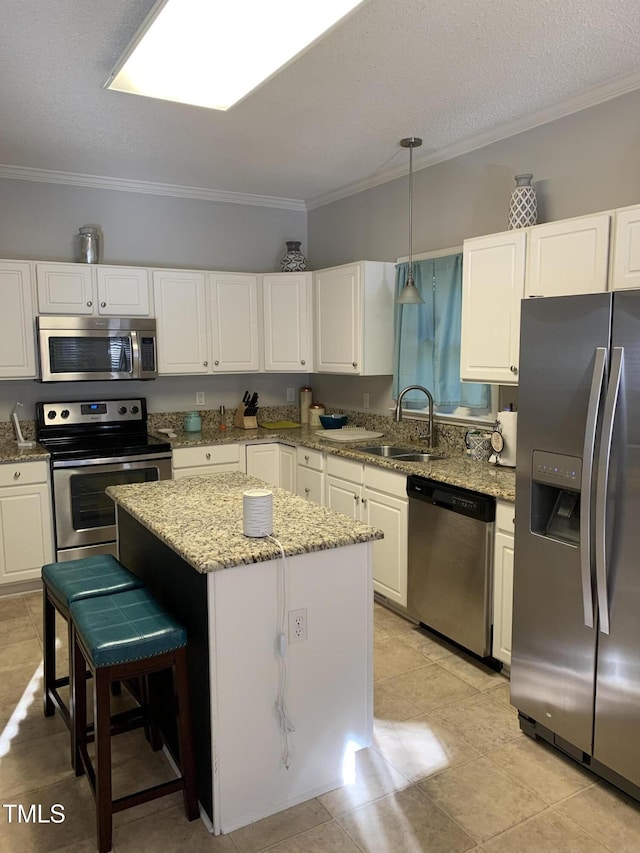 352 Riverstone Dr, Clayton, NC 27527 - kitchen with appliances with stainless steel finishes, a kitchen island, crown molding, a sink, and white cabinetry