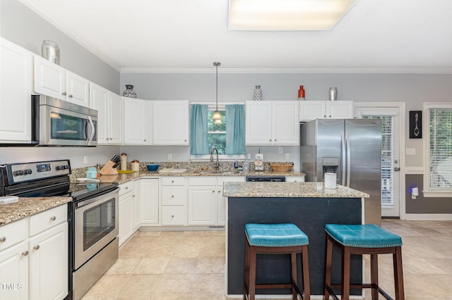 352 Riverstone Dr, Clayton, NC 27527 - kitchen featuring appliances with stainless steel finishes, crown molding, a kitchen breakfast bar, white cabinetry, and a center island