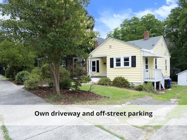 1410 Shawnee St, Durham, NC 27701 - view of front facade featuring a chimney, a front lawn, and a shingled roof