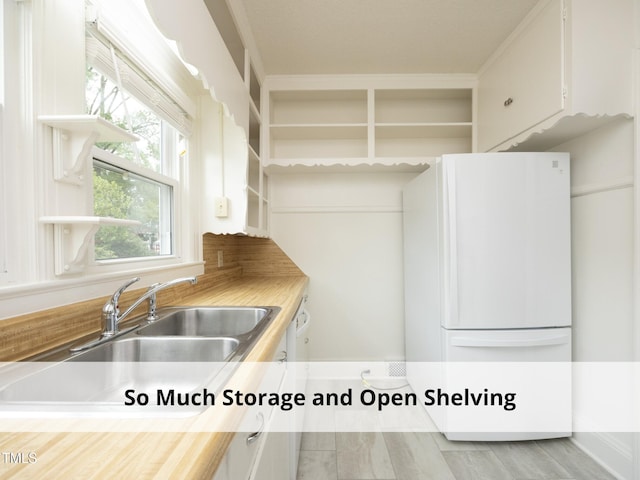 1410 Shawnee St, Durham, NC 27701 - kitchen featuring open shelves, freestanding refrigerator, and white cabinets