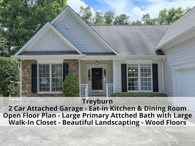 603 Red Cedar Cir, Durham, NC 27712 - view of front facade with stone siding, roof with shingles, a garage, and a porch