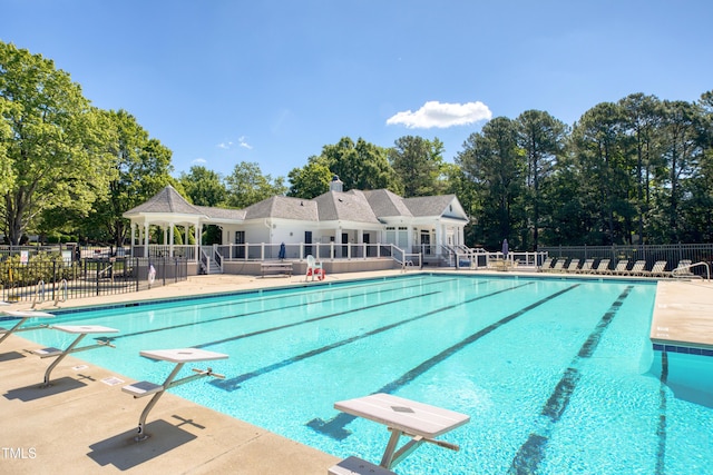203 Halls Mill Dr, Cary, NC 27519 - community pool featuring a diving board, a patio area, and view of scattered trees
