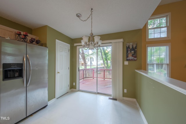 203 Halls Mill Dr, Cary, NC 27519 - unfurnished dining area with a chandelier, healthy amount of natural light, baseboards, and a textured ceiling