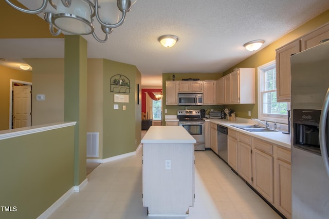 203 Halls Mill Dr, Cary, NC 27519 - kitchen featuring appliances with stainless steel finishes, a sink, light countertops, a chandelier, and a kitchen island