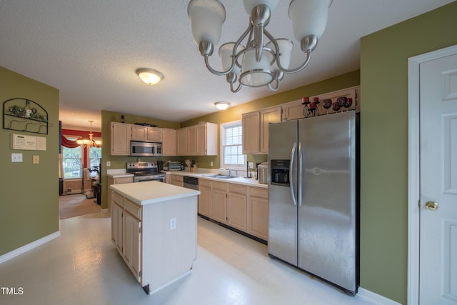 203 Halls Mill Dr, Cary, NC 27519 - kitchen with a chandelier, appliances with stainless steel finishes, a sink, light countertops, and a kitchen island