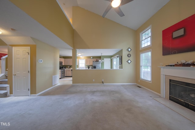 203 Halls Mill Dr, Cary, NC 27519 - unfurnished living room with light colored carpet, high vaulted ceiling, a high end fireplace, a ceiling fan, and baseboards
