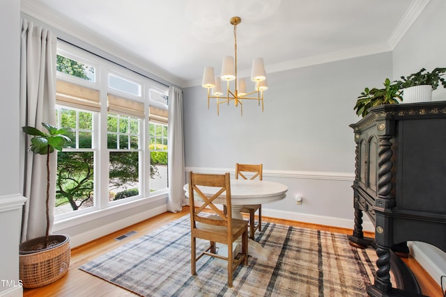 3304 Buck Run Trl, Wake Forest, NC 27587 - dining area with a chandelier, ornamental molding, and wood finished floors