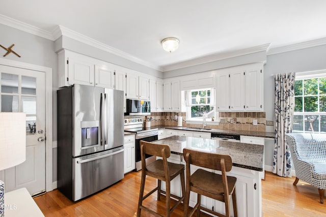 3304 Buck Run Trl, Wake Forest, NC 27587 - kitchen featuring appliances with stainless steel finishes, healthy amount of natural light, light wood-style flooring, and ornamental molding