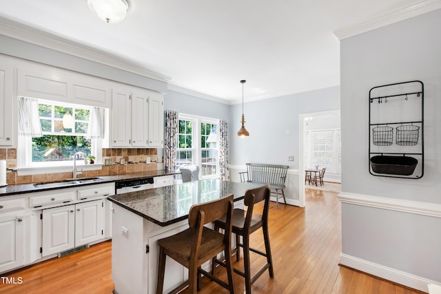 3304 Buck Run Trl, Wake Forest, NC 27587 - kitchen with white cabinets, decorative backsplash, a breakfast bar area, light wood-style floors, and pendant lighting