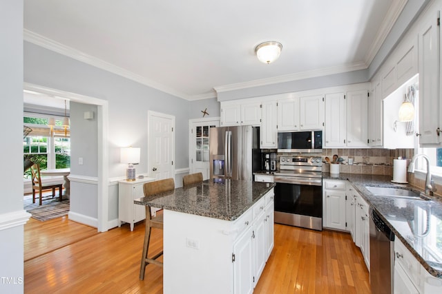 3304 Buck Run Trl, Wake Forest, NC 27587 - kitchen with appliances with stainless steel finishes, light wood-style floors, white cabinetry, crown molding, and dark stone countertops