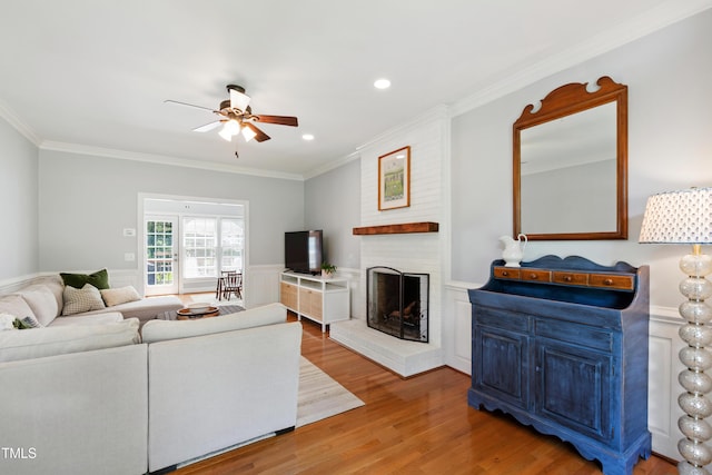 3304 Buck Run Trl, Wake Forest, NC 27587 - living area featuring a ceiling fan, a brick fireplace, crown molding, wood finished floors, and a wainscoted wall