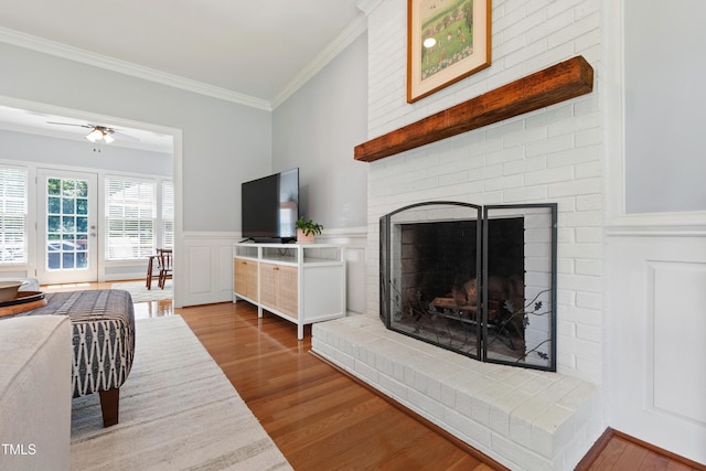 3304 Buck Run Trl, Wake Forest, NC 27587 - living area featuring ornamental molding, wood finished floors, a brick fireplace, a wainscoted wall, and a ceiling fan