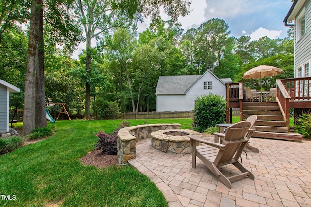 3304 Buck Run Trl, Wake Forest, NC 27587 - view of patio featuring a fire pit, a playground, a deck, stairs, and view of wooded area