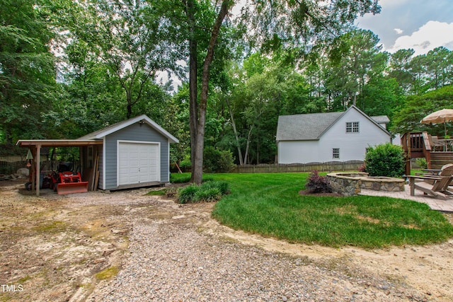 3304 Buck Run Trl, Wake Forest, NC 27587 - view of yard with dirt driveway, an outbuilding, a garage, a fire pit, and view of wooded area