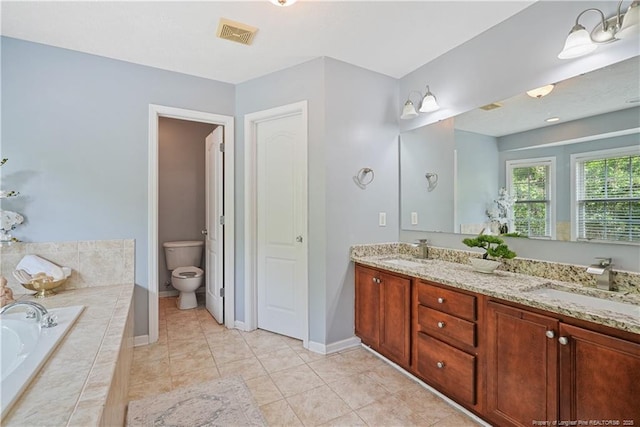 4055 Beaubien Dr, Fayetteville, NC 28306 - bathroom featuring a bath, double vanity, toilet, baseboards, and tile patterned floors
