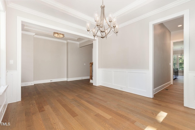 59 Cardinal Dr, Whispering Pines, NC 28327 - unfurnished dining area featuring a chandelier, wood finished floors, a wainscoted wall, ornamental molding, and a decorative wall