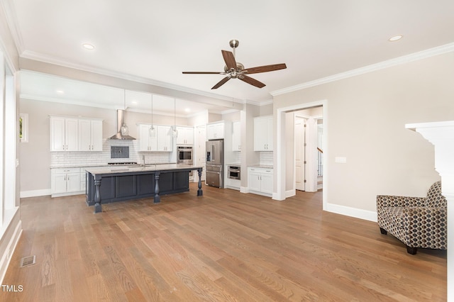 59 Cardinal Dr, Whispering Pines, NC 28327 - kitchen featuring wall chimney range hood, appliances with stainless steel finishes, white cabinets, a ceiling fan, and tasteful backsplash