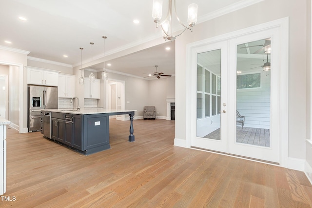 59 Cardinal Dr, Whispering Pines, NC 28327 - kitchen featuring ceiling fan, appliances with stainless steel finishes, white cabinets, light wood-style flooring, and ornamental molding