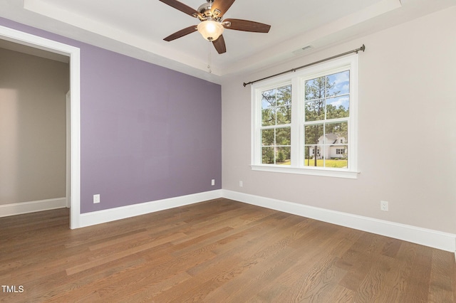 59 Cardinal Dr, Whispering Pines, NC 28327 - empty room featuring a raised ceiling, wood finished floors, a ceiling fan, and baseboards