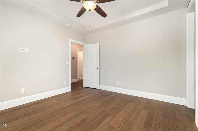 59 Cardinal Dr, Whispering Pines, NC 28327 - unfurnished room with ceiling fan, a raised ceiling, dark wood-type flooring, and baseboards