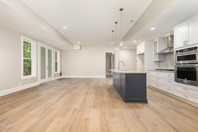 59 Cardinal Dr, Whispering Pines, NC 28327 - kitchen featuring wall chimney exhaust hood, stainless steel appliances, white cabinetry, light wood-type flooring, and recessed lighting