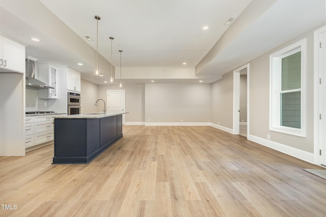 59 Cardinal Dr, Whispering Pines, NC 28327 - kitchen with wall chimney exhaust hood, stainless steel appliances, a sink, white cabinetry, and light wood finished floors