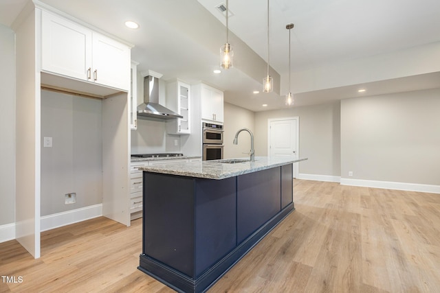 59 Cardinal Dr, Whispering Pines, NC 28327 - kitchen with wall chimney range hood, a sink, appliances with stainless steel finishes, white cabinets, and light wood finished floors